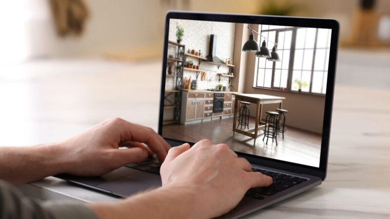 Man looking for house on real estate market website at table, closeup