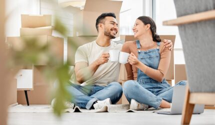 Happy couple, cheers and drinking coffee in new home to celebrate moving to apartment. Man, woman or toast with cup in property for real estate investment, success or relocate to dream house together